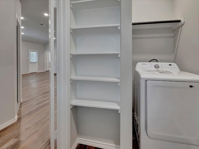 laundry area featuring recessed lighting, washer / clothes dryer, wood finished floors, laundry area, and baseboards