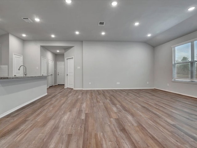 unfurnished living room with baseboards, light wood finished floors, visible vents, and recessed lighting