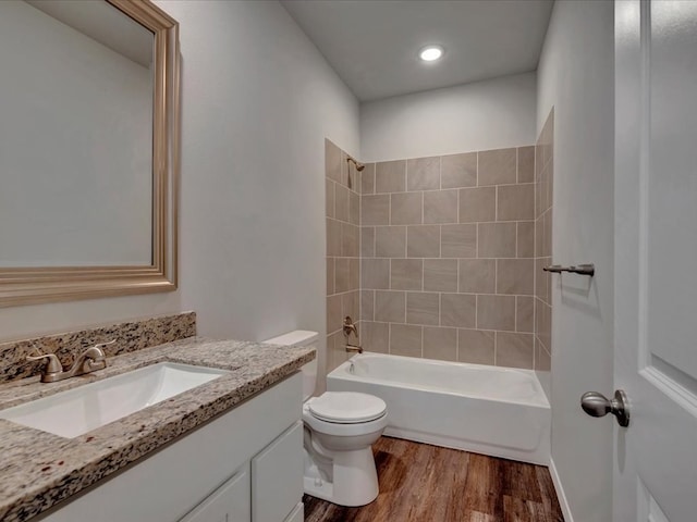 bathroom featuring toilet,  shower combination, wood finished floors, and vanity