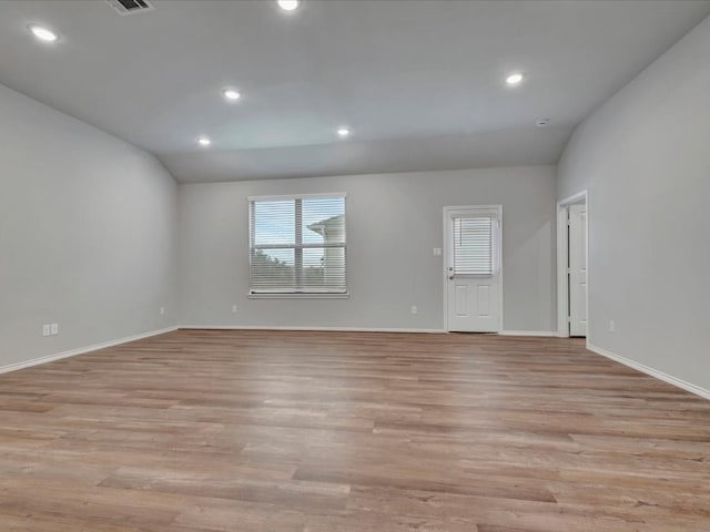 spare room with recessed lighting, visible vents, baseboards, vaulted ceiling, and light wood-type flooring