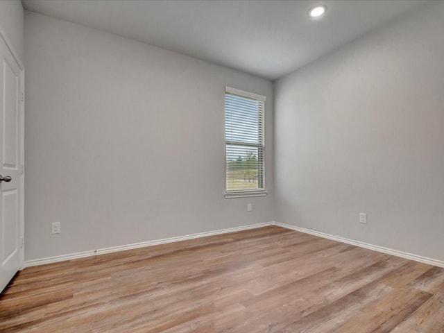 unfurnished room featuring light wood finished floors, baseboards, and recessed lighting