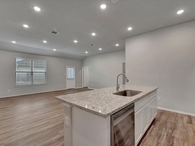 kitchen with visible vents, dishwasher, an island with sink, white cabinetry, and a sink