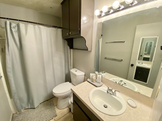 bathroom with vanity, tile patterned floors, a shower with curtain, toilet, and a textured ceiling