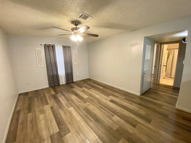 unfurnished room featuring a textured ceiling, ceiling fan, and dark wood-type flooring