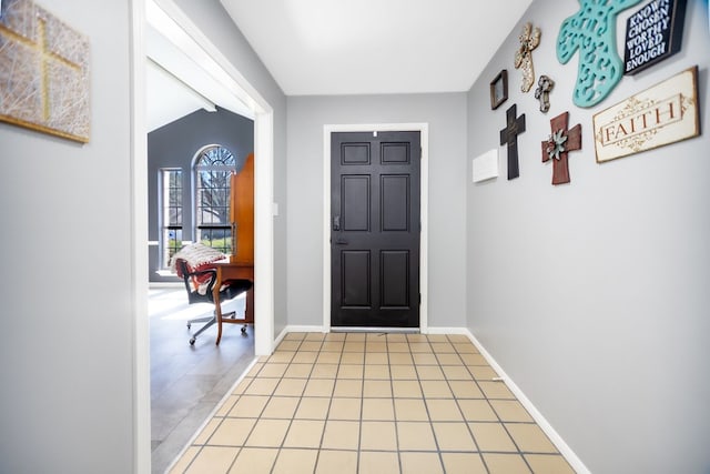 foyer featuring light tile patterned flooring and baseboards