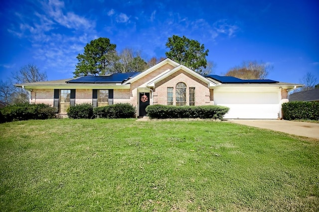 ranch-style house with an attached garage, a front lawn, solar panels, and brick siding