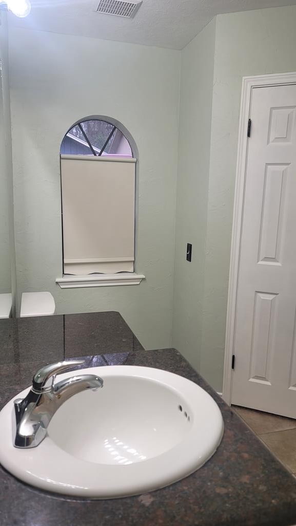 bathroom with a sink, visible vents, and tile patterned floors