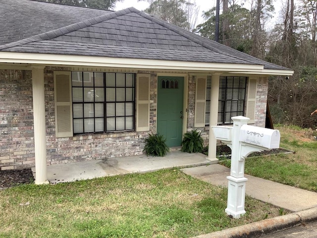 view of front of house with brick siding and a shingled roof