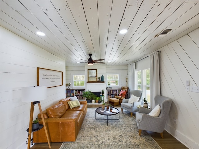 living room with wooden ceiling, wooden walls, and a healthy amount of sunlight