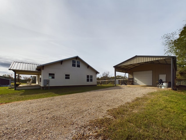 view of home's exterior with a lawn, an outbuilding, a carport, and a garage