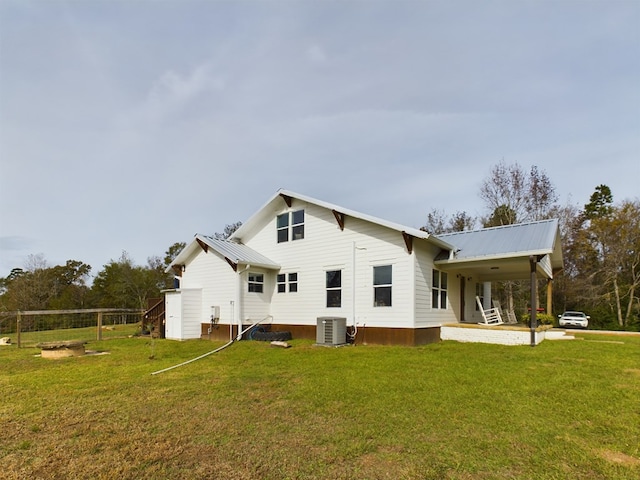 back of house featuring a lawn, cooling unit, and covered porch