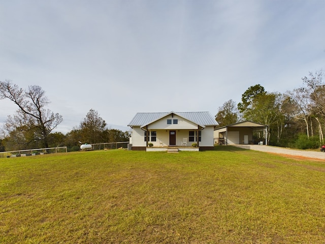 view of front of home with a carport, covered porch, an outbuilding, and a front lawn