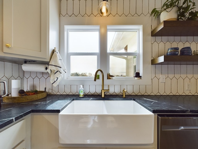 kitchen with dishwasher, backsplash, white cabinets, and sink