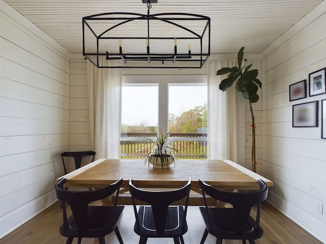 dining area with wood walls and wood-type flooring