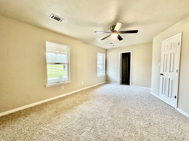 unfurnished bedroom with multiple windows, carpet, a textured ceiling, and ceiling fan