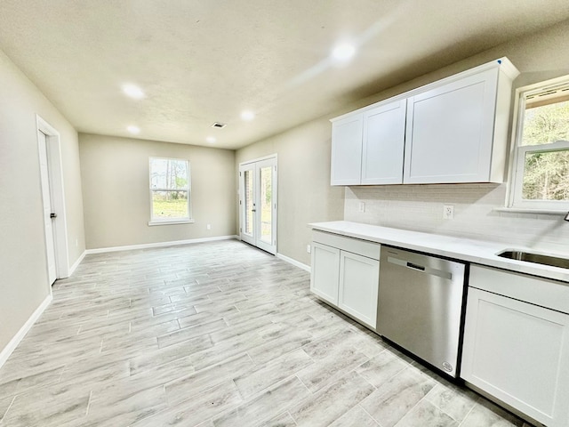 kitchen with french doors, white cabinets, stainless steel dishwasher, and sink