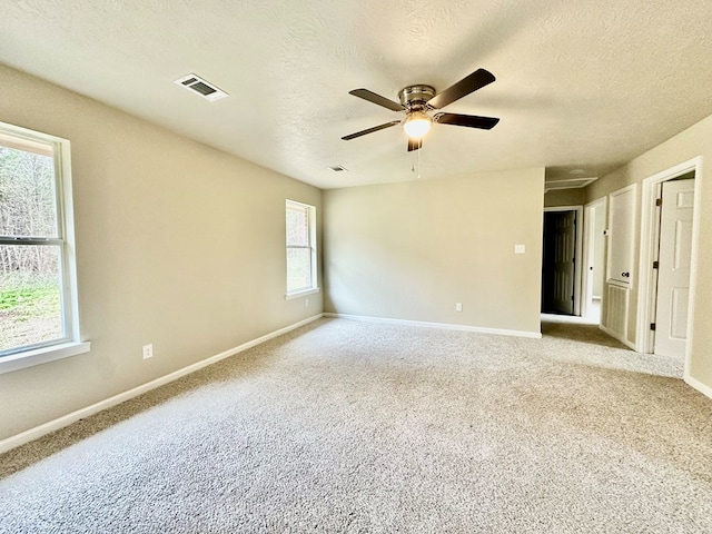 unfurnished room with ceiling fan, light carpet, and a wealth of natural light