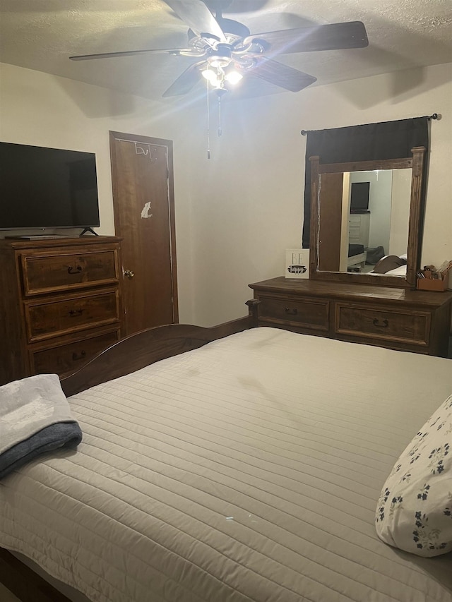 bedroom featuring ceiling fan and a textured ceiling