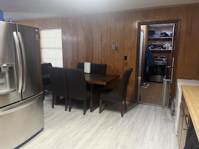 dining area featuring wood walls and light hardwood / wood-style floors