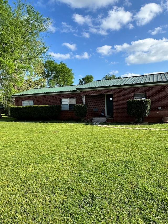 231 Miller St, Alto, TX 75033 - rear view of house featuring a yard, brick siding, and a metal roof