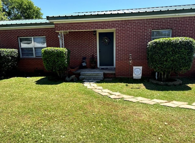 231 Miller St, Alto, TX 75033 - view of front of home with brick siding, a front lawn, and a metal roof