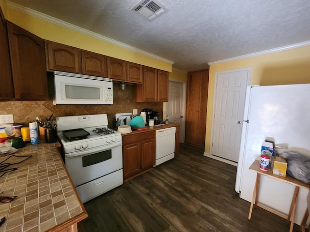 4710 County Road 082, Jasper, TX 75951 - kitchen with white appliances, tile counters, dark wood finished floors, crown molding, and backsplash