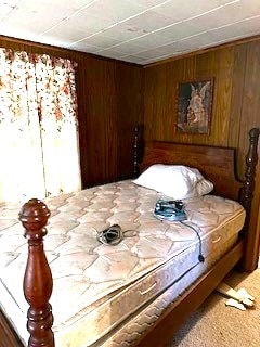 bedroom with wood walls