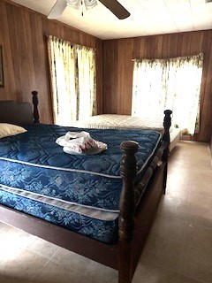 bedroom with wood walls and ceiling fan