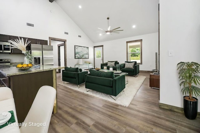 living area with high vaulted ceiling, wood finished floors, ceiling fan, beamed ceiling, and baseboards