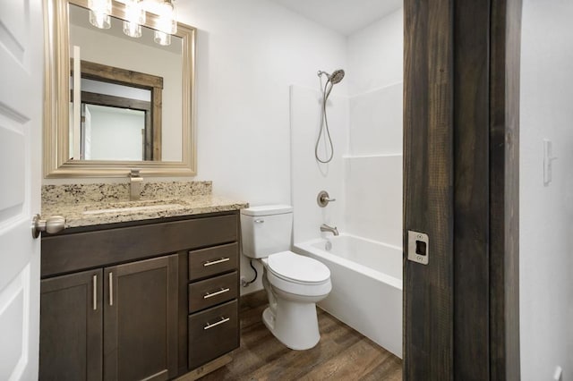bathroom featuring wood finished floors, vanity, toilet, and shower / bath combination