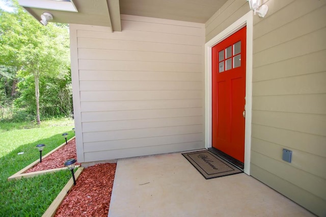 doorway to property featuring a lawn