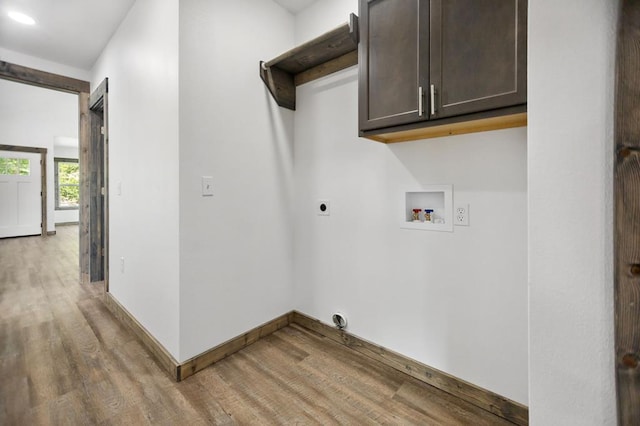 laundry room featuring electric dryer hookup, light wood-type flooring, washer hookup, and cabinet space
