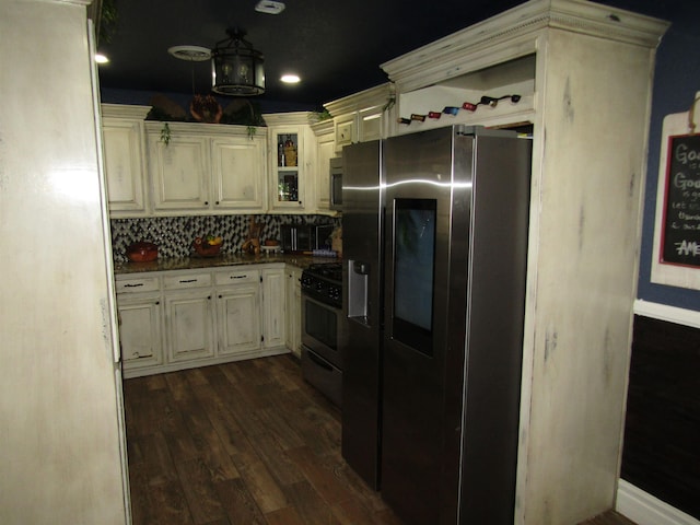 kitchen featuring decorative backsplash, dark hardwood / wood-style flooring, stainless steel appliances, and cream cabinets