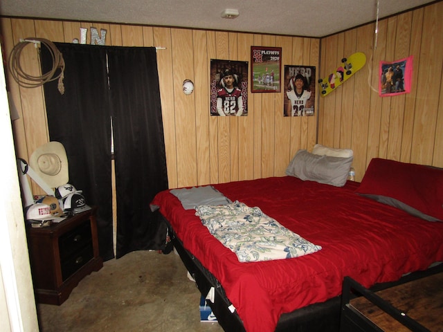 bedroom featuring wooden walls and a textured ceiling