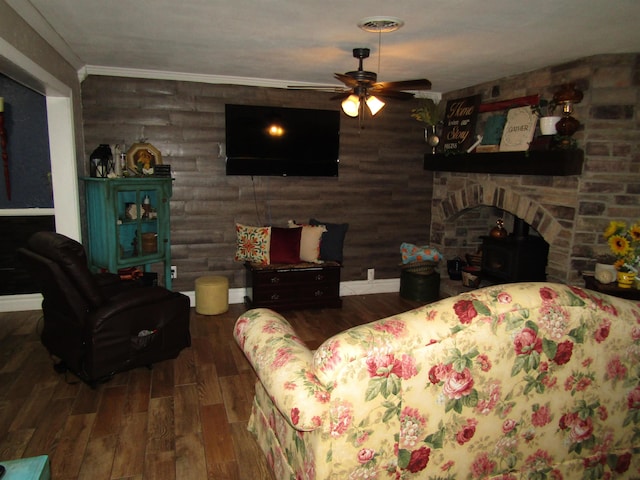 living room with dark hardwood / wood-style flooring, ceiling fan, and crown molding