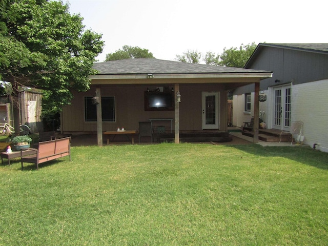 rear view of house with french doors and a lawn