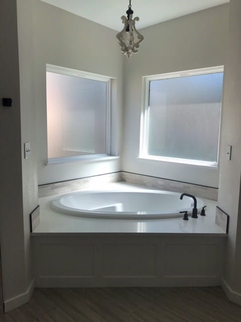 bathroom with hardwood / wood-style flooring and an inviting chandelier