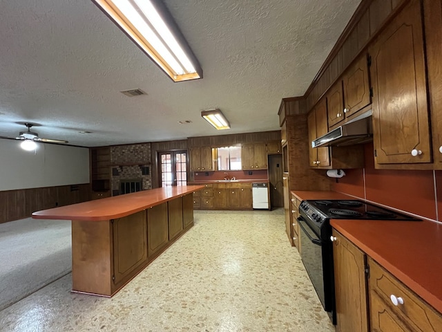 kitchen featuring electric range, a fireplace, ceiling fan, and a textured ceiling