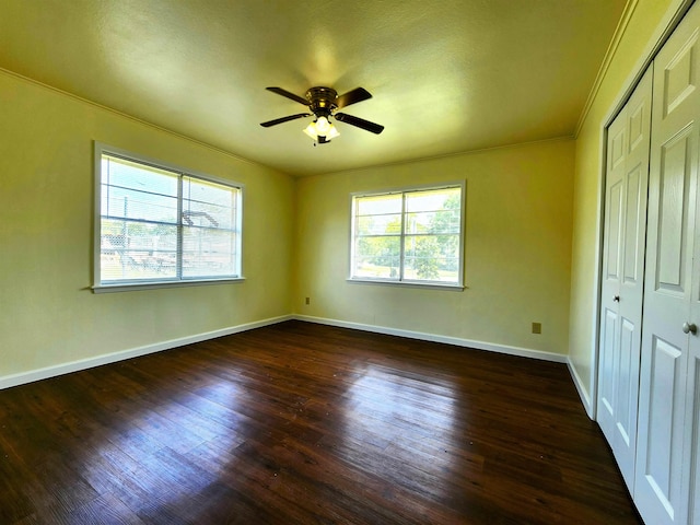 unfurnished bedroom with a closet, ornamental molding, dark hardwood / wood-style floors, and ceiling fan