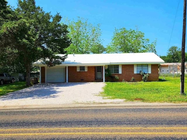 ranch-style house featuring a garage and a front lawn