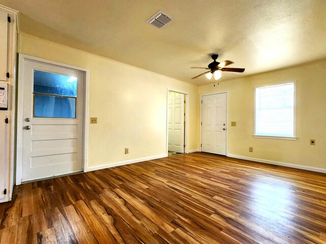 foyer featuring ceiling fan, ornamental molding, dark hardwood / wood-style flooring, and a textured ceiling