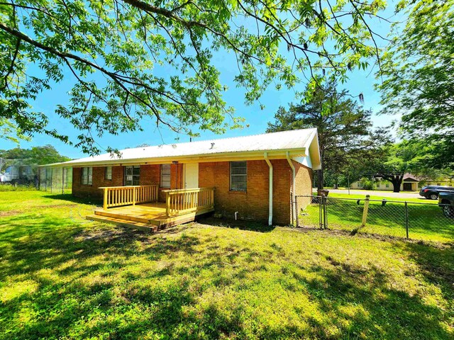 back of property featuring a yard and a deck