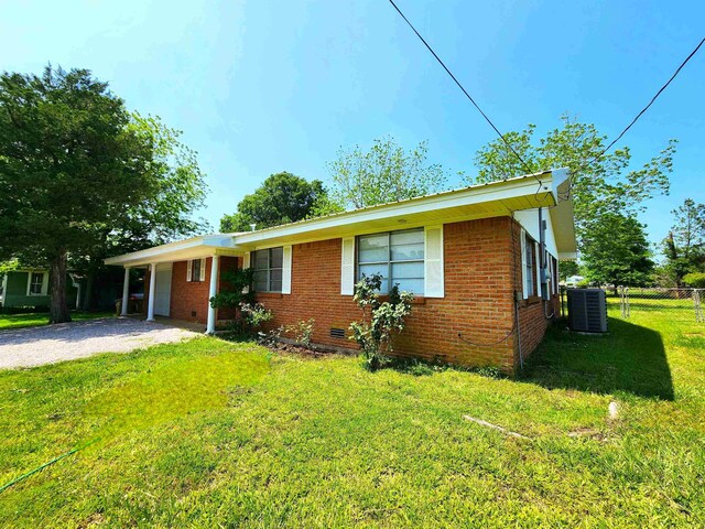 view of front of property featuring central AC unit, a front yard, and a carport