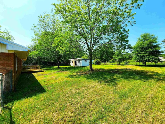 view of yard featuring an outdoor structure and a deck