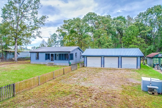 single story home with an outbuilding, a garage, and a front yard