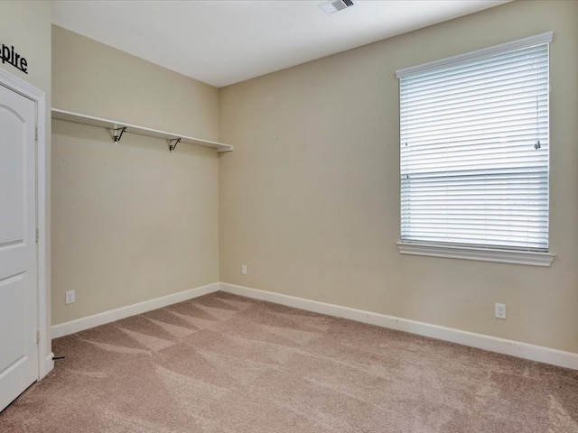 spare room with light colored carpet and a healthy amount of sunlight