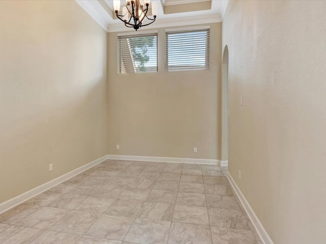 spare room featuring a notable chandelier and crown molding