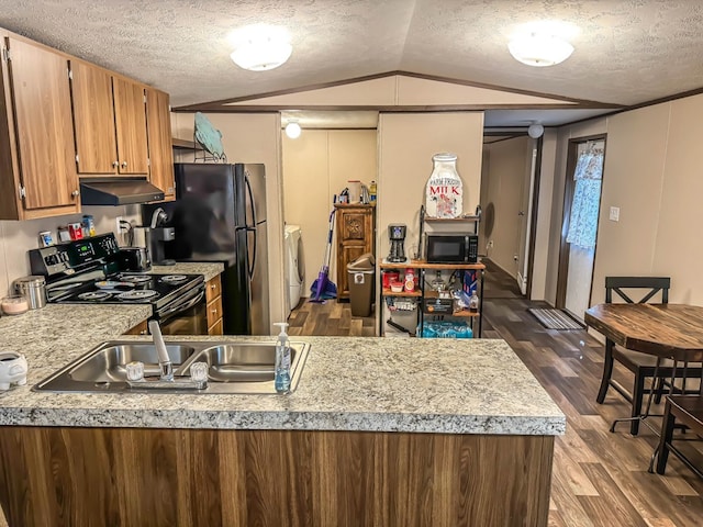 kitchen with dark wood-type flooring, black appliances, sink, vaulted ceiling, and separate washer and dryer