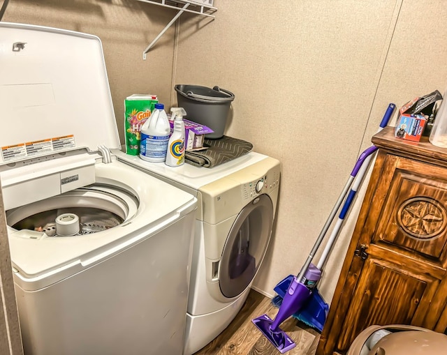 laundry area with hardwood / wood-style floors and washing machine and clothes dryer