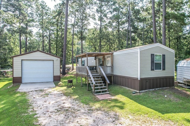 view of front of property with a porch, a garage, an outbuilding, and a front yard